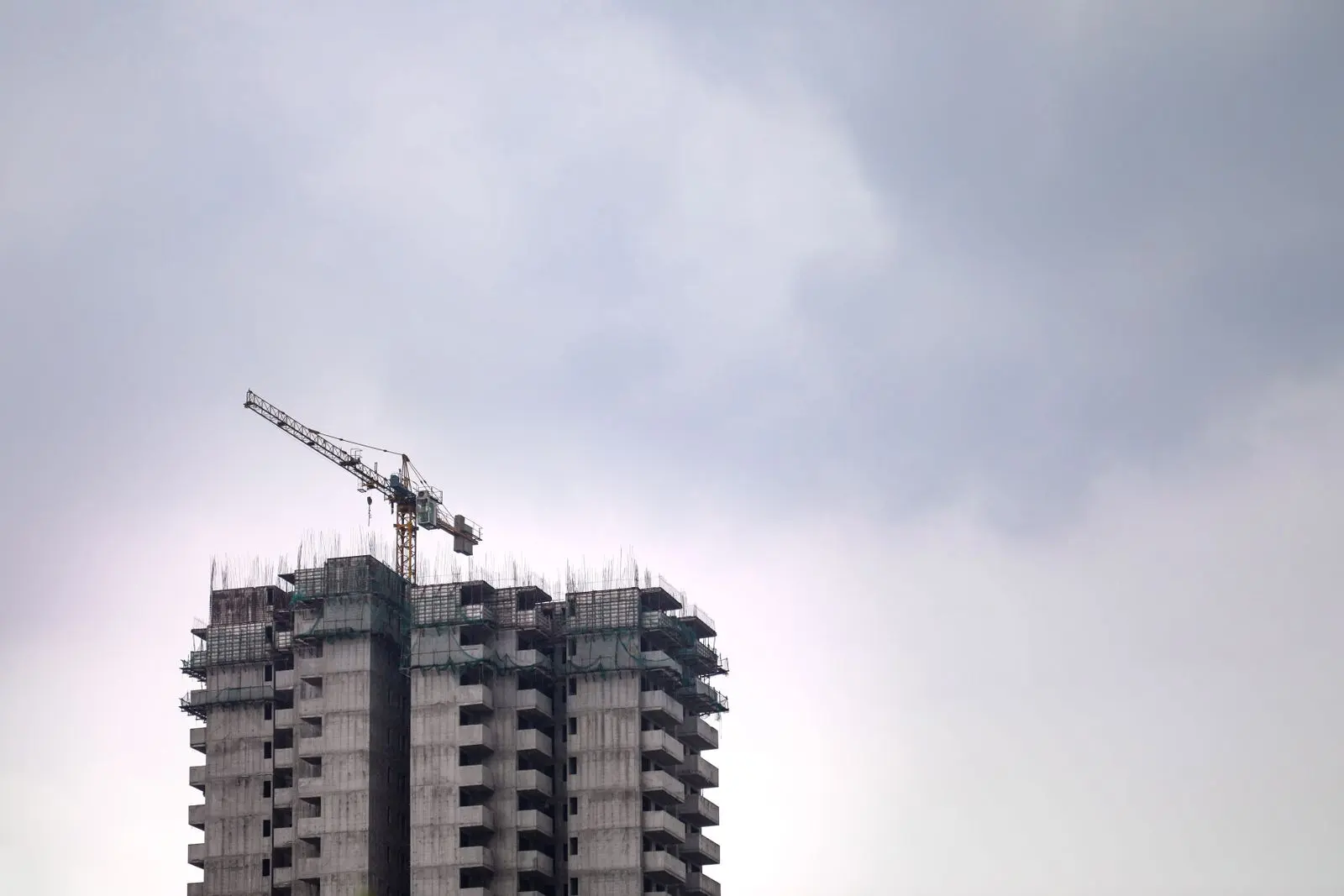 High-rise construction site with tower crane — representative commercial construction reference